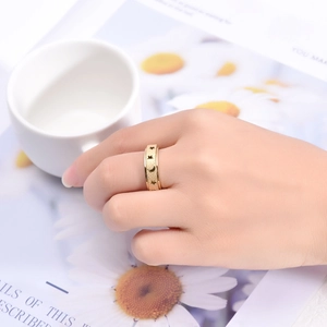 Nahaufnahme eines goldenen Edelstahlrings mit Sternen und Monden auf der Hand eines Modells