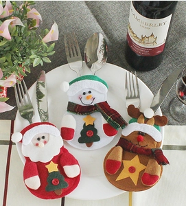 Three Christmas cutlery holders featuring Santa and reindeer on a white ceramic plate