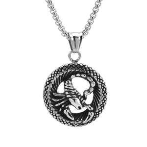 Gros plan d'un pendentif zodiaque en argent avec motif de scorpion et cadre texturé