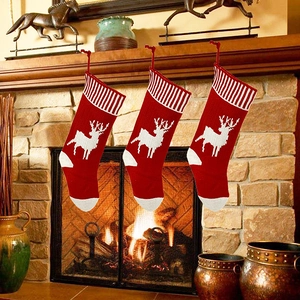 Close-up of three red and white knitted Christmas stockings with reindeer patterns