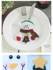 Detail of a snowman cutlery holder with a red and green plaid scarf for Christmas table decor