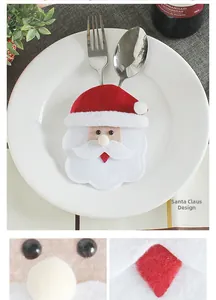 Detail of Santa Claus felt cutlery holder set on a white dinner plate for table decor