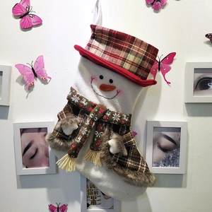 Detail of handmade Christmas stocking featuring a 3D snowman with plaid hat and green scarf