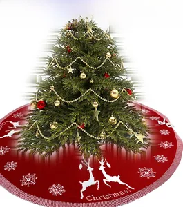 Macro detail of red knitted Christmas tree skirt featuring white reindeer and snowflake patterns