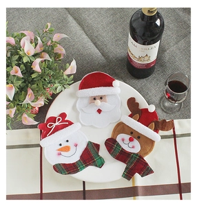 Detailed view of Santa, Snowman and Reindeer felt cutlery holders on a white plate