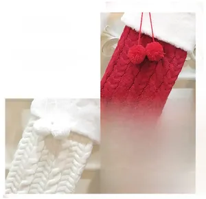 Detail of knitted Christmas stockings with faux fur trim and pom-pom decorations