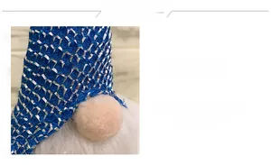 Detail of a Christmas gnome featuring a shiny blue metallic hat and soft white faux fur
