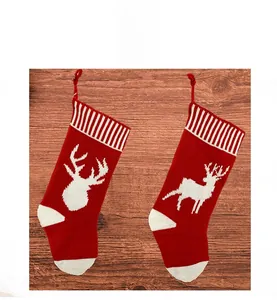 Detail of red and white knitted Christmas stockings with deer patterns and hanging loops