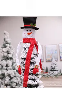 Detail view of plush snowman Christmas tree topper with red scarf and black top hat