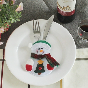 Christmas snowman cutlery holder bag with green hat and scarf on a festive dining table