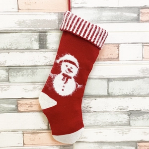 Chaussette de Noël en tricot rouge avec motif bonhomme de neige et revers rayé sur mur