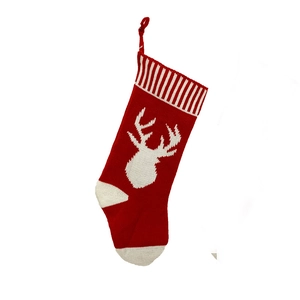 Detail of red knit Christmas stocking with white reindeer pattern and striped cuff