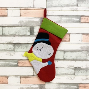 Classic red Christmas stocking with green trim and cute snowman embroidery hanging on a wall