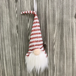 Close-up of a Christmas gnome ornament with red striped sequined hat and white beard