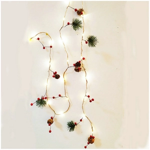 Christmas LED string light with pine needles cones and red berries on warm white copper wire