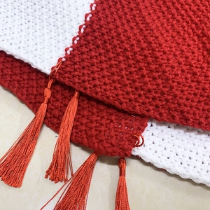 Knitted red and white Christmas tree skirt with decorative fringe and thick texture