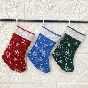 Close-up of knitted Christmas stockings in red blue and green with white snowflake patterns
