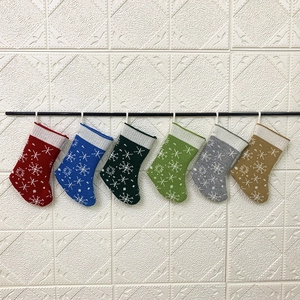 Detail of knitted Christmas stockings in six colors with white snowflake patterns