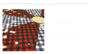 Detail of red and black checkered Christmas tree skirt with white reindeer and snowflake prints