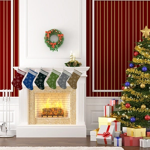 Set of six knitted Christmas stockings with snowflake patterns hung on a festive fireplace