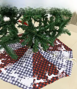 Detail of red and white plaid Christmas tree skirt with reindeer and snowflake printing