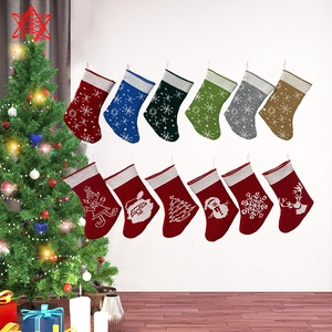 Detailed view of twelve knitted Christmas stockings with festive patterns on a white wall