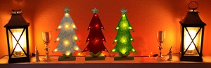 Close-up of felt desktop Christmas trees with LED lights in white, red, and green colors