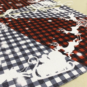 Plaid Christmas drawstring gift bags with reindeer and Santa patterns in red and black