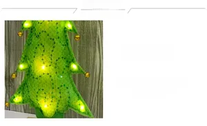 Close-up of green felt Christmas tree with golden bells and warm yellow LED lights
