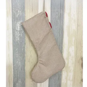 Detailansicht der strukturierten Jute-Weihnachtssocke mit roter Schlaufe auf Holzdekor