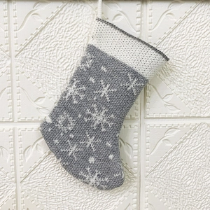 Close-up of gray and white knitted Christmas stocking with snowflake patterns