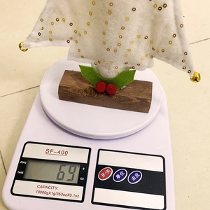 Detail view of a 69g felt Christmas tree decoration on a compact wooden base stand