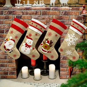 Vierteiliges Set Weihnachtsstrümpfe aus Leinen mit Weihnachtsmann am Kamin aufgehängt