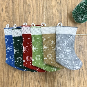 Set of six knitted Christmas stockings with snowflake patterns on a wooden background