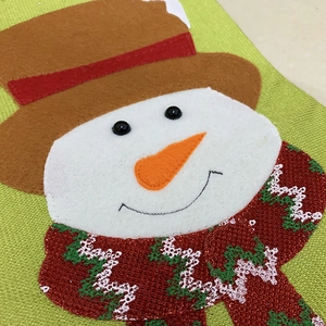 Detailed view of handmade snowman Christmas stocking featuring 3D felt and woven textures