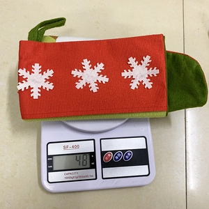 Detailed view of a red and green Christmas stocking gift bag weighing 48g on a digital scale