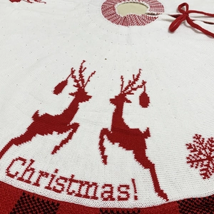 Red and white knitted Christmas tree skirt featuring reindeer patterns and bow ties