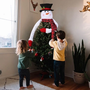 Detailed view of snowman Christmas tree topper with red scarf and long bendable arms