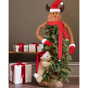Detail view of reindeer tree topper and plush polar bear with festive scarves and hats