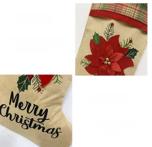 Détail d'une chaussette de Noël en toile avec fleur rouge et broderie Merry Christmas