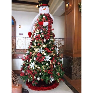 Close-up of a snowman tree topper with black top hat and festive red plaid scarf