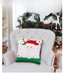 Detail of 3D Santa Claus throw pillow with red green dots on a cozy white sofa