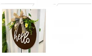 Detail of wooden welcome sign featuring white hello script and rustic floral bow decoration