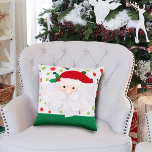 3D Santa Claus throw pillow with polka dots on a chair next to a Christmas tree