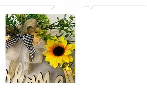 Detail of sunflower welcome wreath with rustic bows and warm glowing LED lights