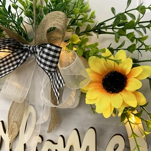 Lighted Easter welcome sign wreath with yellow sunflower, green leaves, and rustic bow