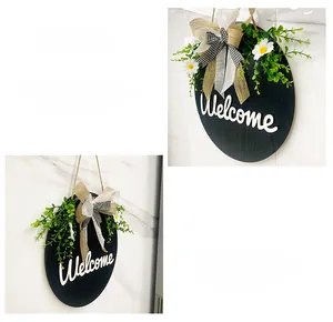 Detail of wooden welcome sign featuring artificial plants and a checkered burlap bow