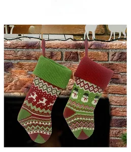 Détail de chaussettes de Noël tricotées avec motifs bonhomme de neige et renne sur la cheminée