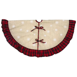 Detail of burlap Christmas tree skirt with white snowflake prints and buffalo plaid ruffled edge