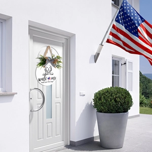 Front door view of a dog-themed welcome sign with green leaves and a plaid bow